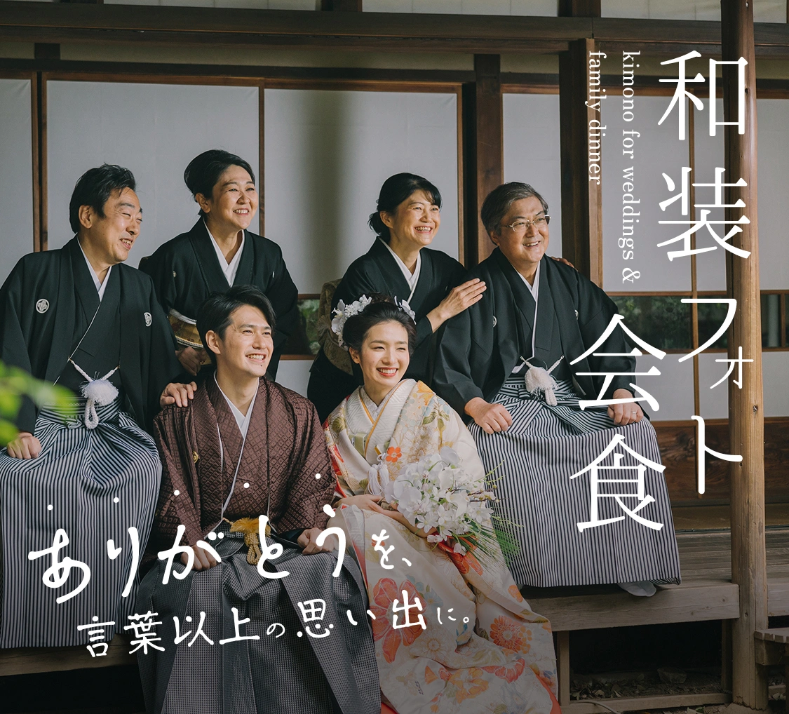 和装姿の新郎新婦とご家族が並んで笑顔を見せる様子