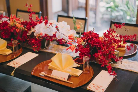 赤い装花と席札が並ぶ会食テーブル