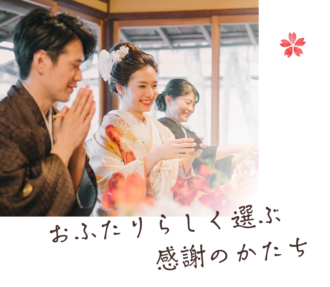 和装姿で手を合わせる新郎新婦