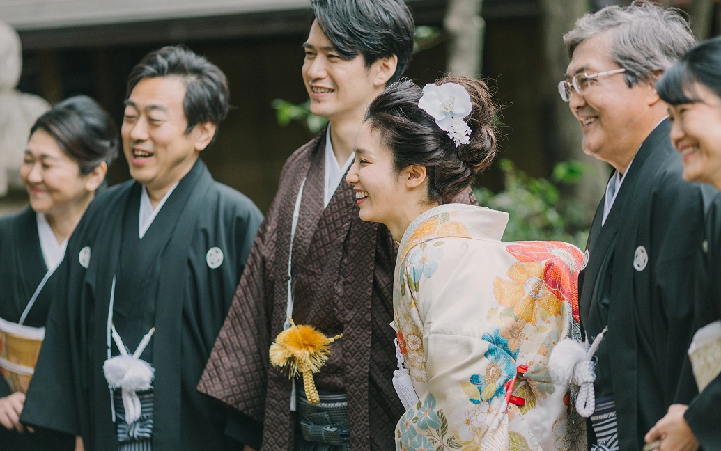 和装姿の新郎新婦と家族が笑顔で並ぶ様子
