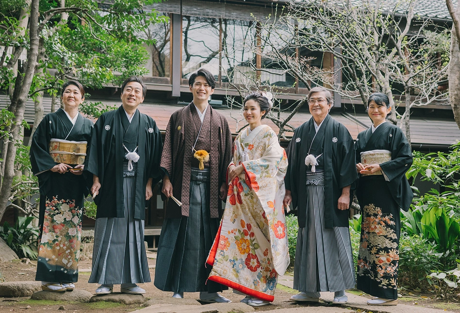 和装姿の新郎新婦と家族が並んで記念撮影をする様子