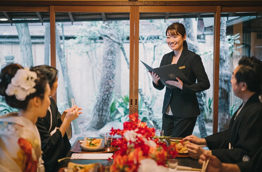 会食会場で司会者の話を聞く新郎新婦