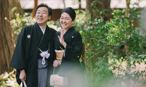 緑を背景に並ぶ和装姿の新郎新婦