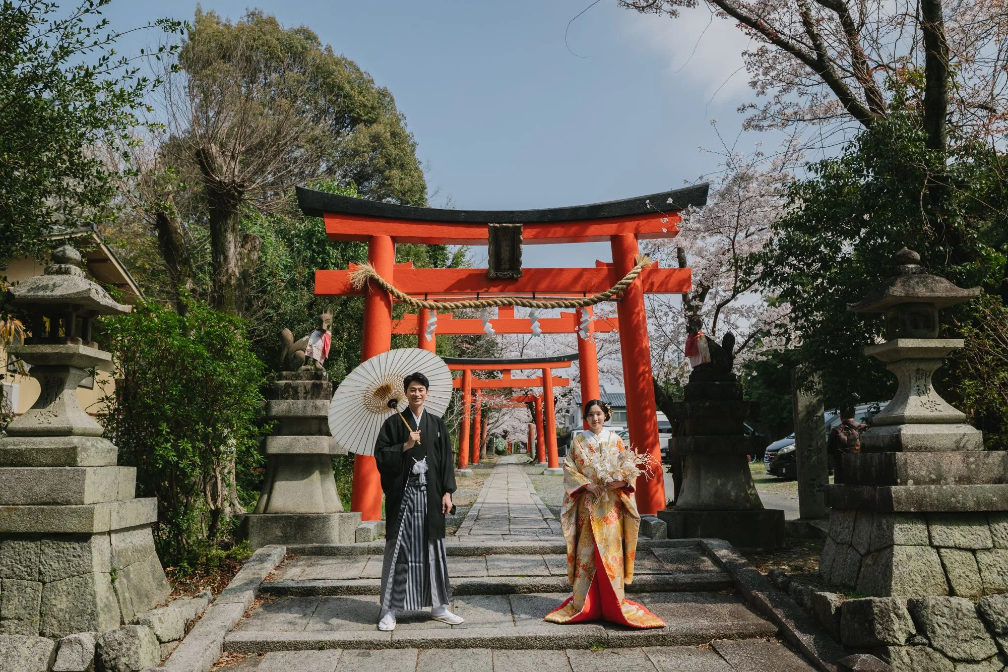 鳥居の参道に立つ和装の新郎新婦